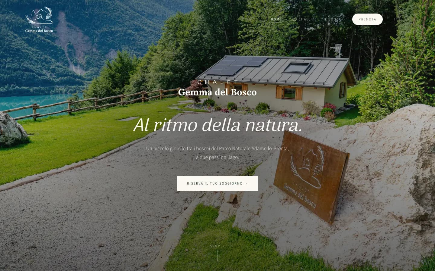 Home di Chalet Gemma del Bosco: lo chalet in legno sul prato con il lago sullo sfondo e il titolo «Al ritmo della natura»